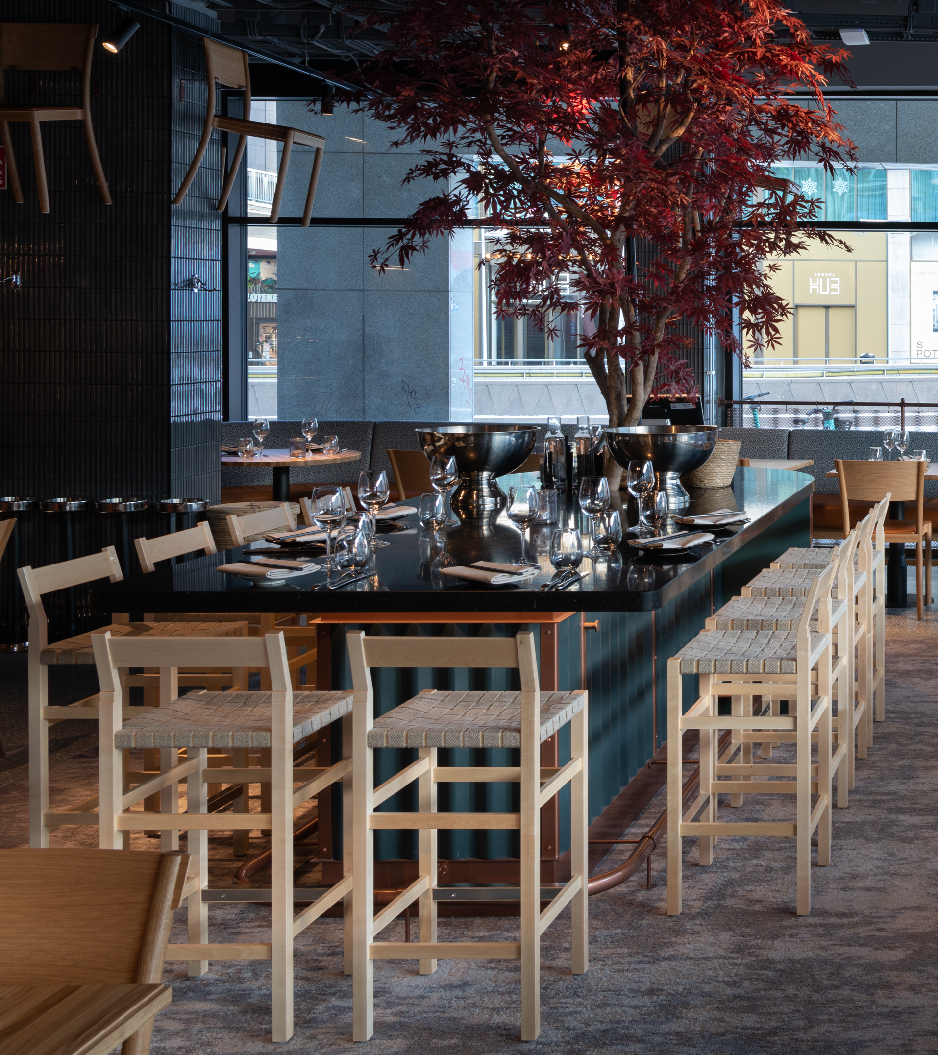 Barstolen Schablon i ljust trä ståendes vid ett bord i restaurangmijlö.