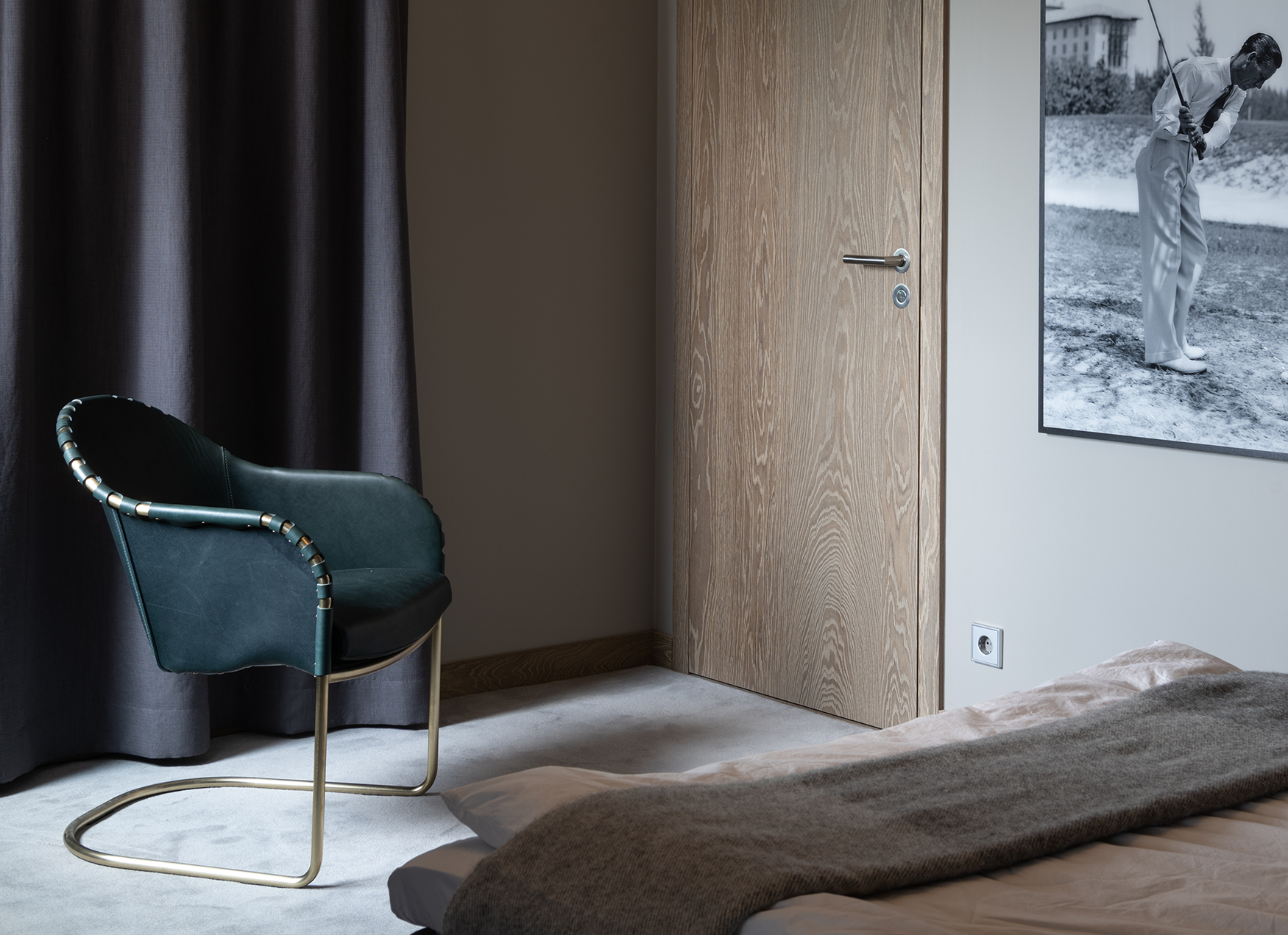 Ingo armchair on a light carpet in a room with textiles on the walls.