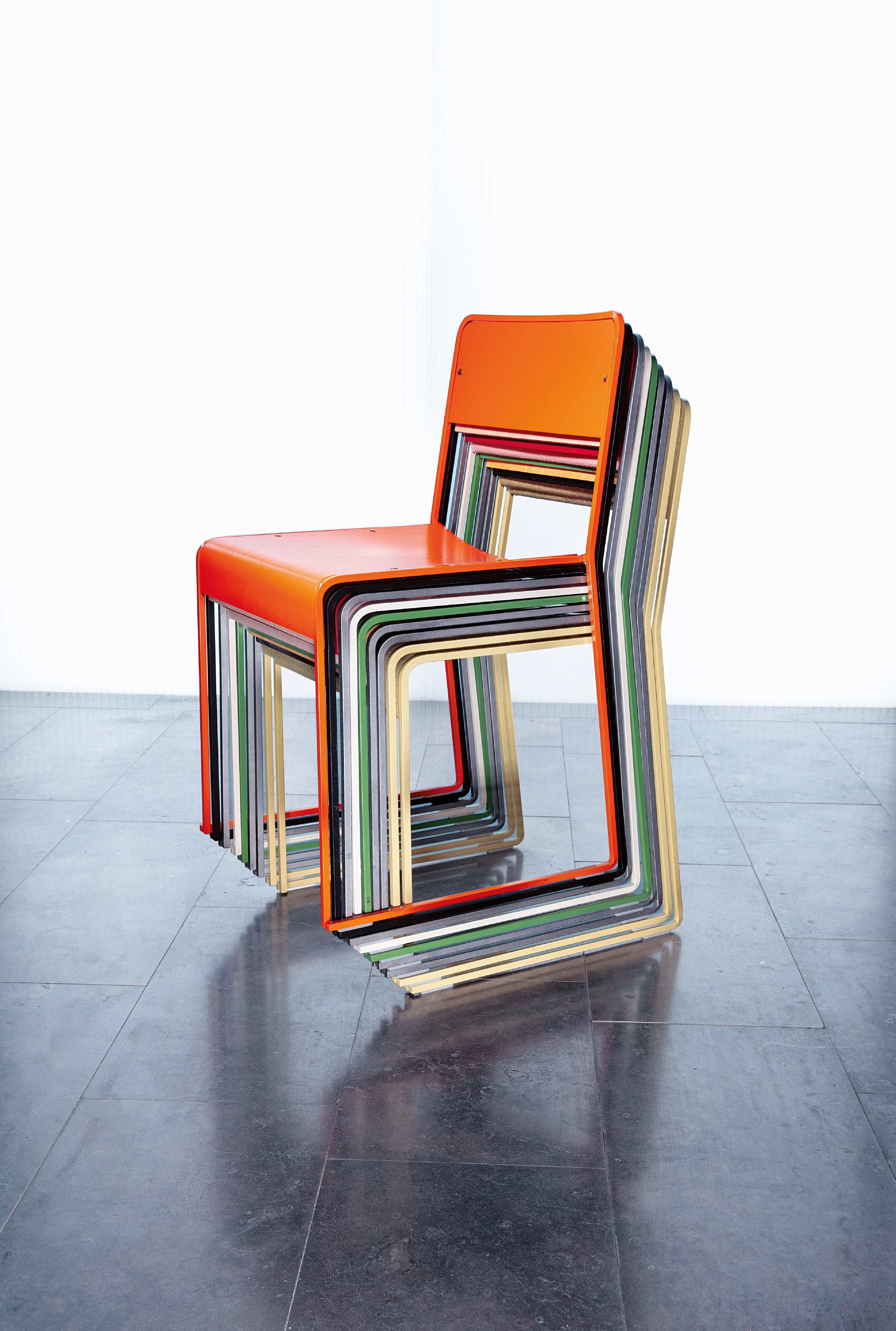 The Sindre chair stacked in a pile of chairs in various colors.