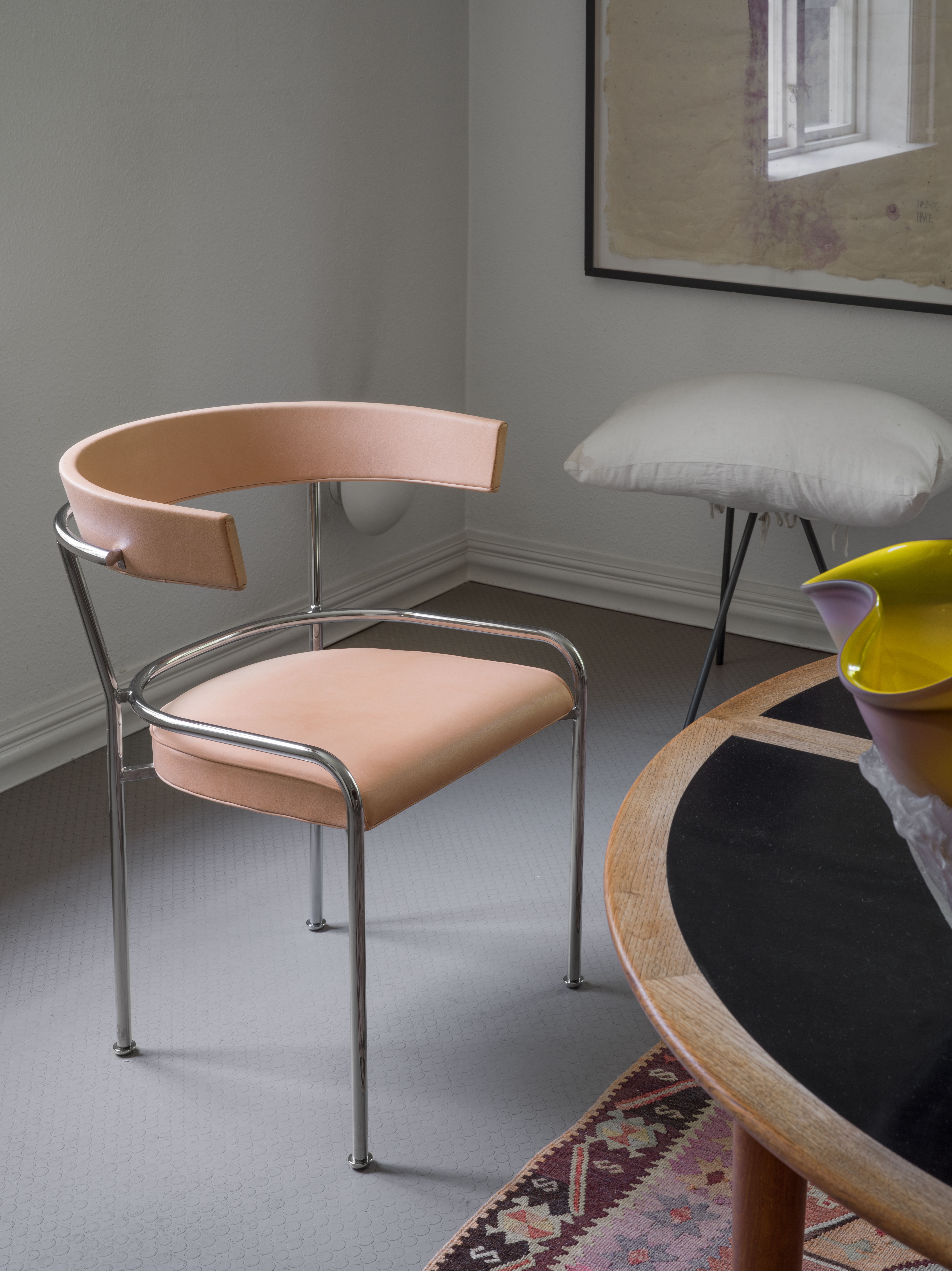 Stol GA-1 av Gunnar Asplund i ljust läder vid ett bord.