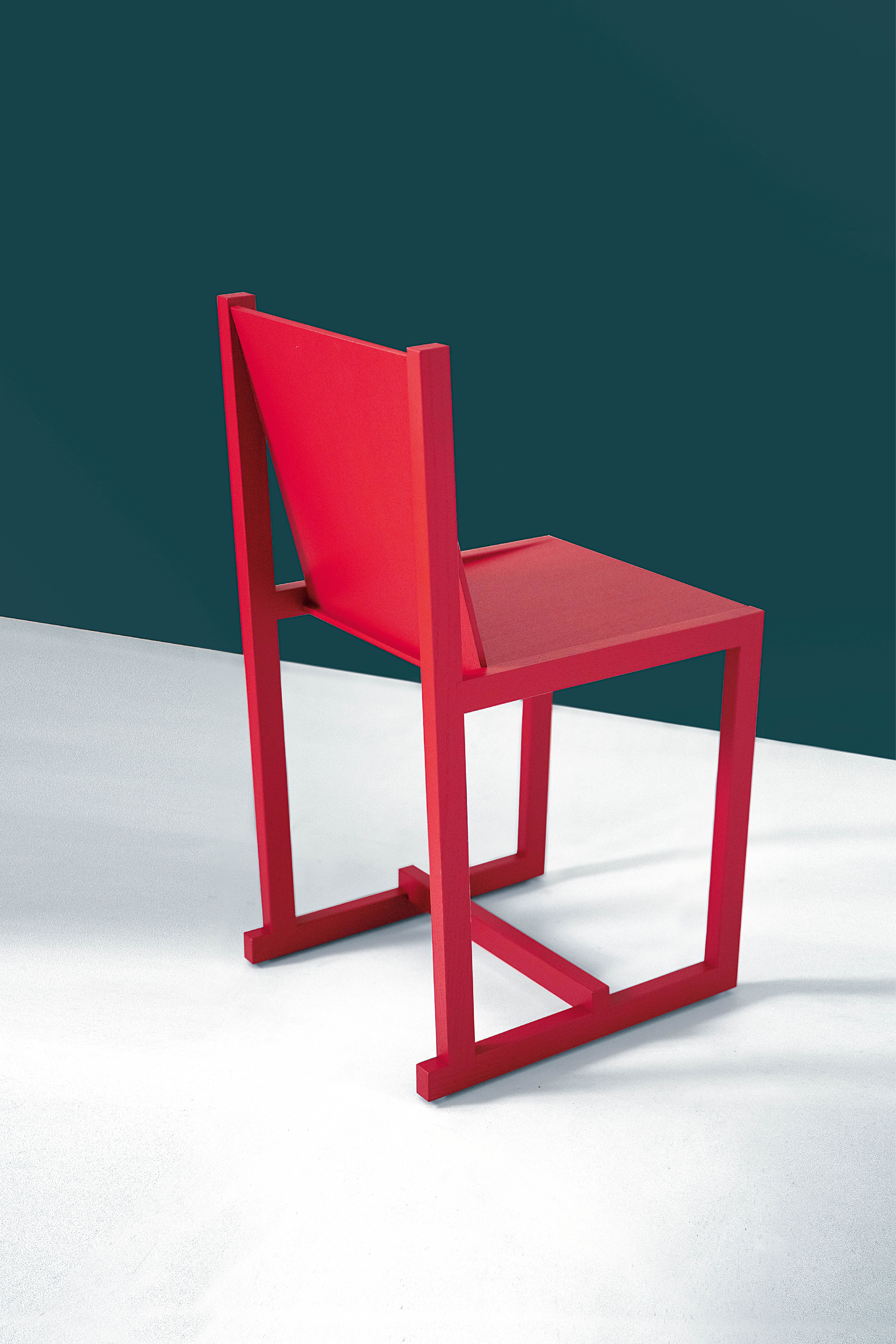 Ono chair in red, seen against a green background.