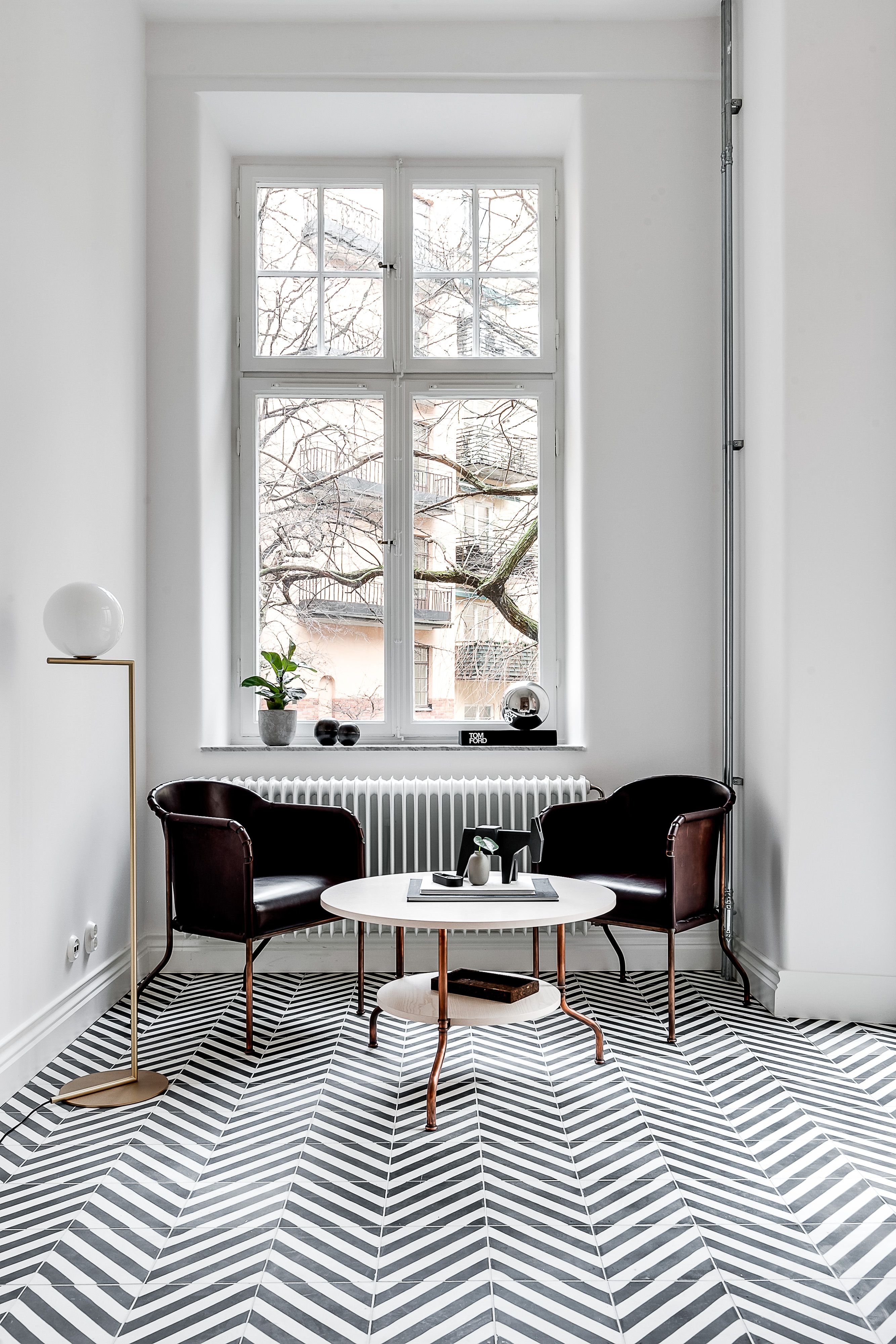 Two Ambassad armchairs behind a Sven table in a room.
